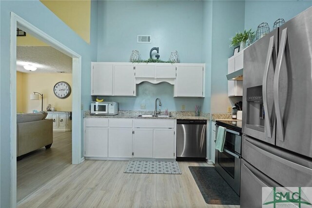 121 Pelican Ln, Richmond Hill, GA 31324 - kitchen with a sink, light wood-style floors, stainless steel appliances, under cabinet range hood, and visible vents