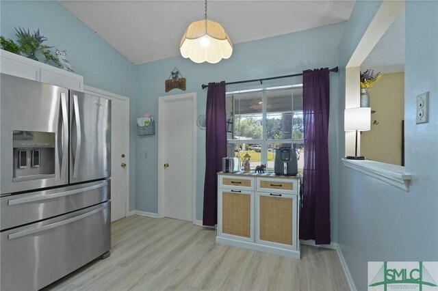 121 Pelican Ln, Richmond Hill, GA 31324 - kitchen with stainless steel fridge, light wood finished floors, and baseboards