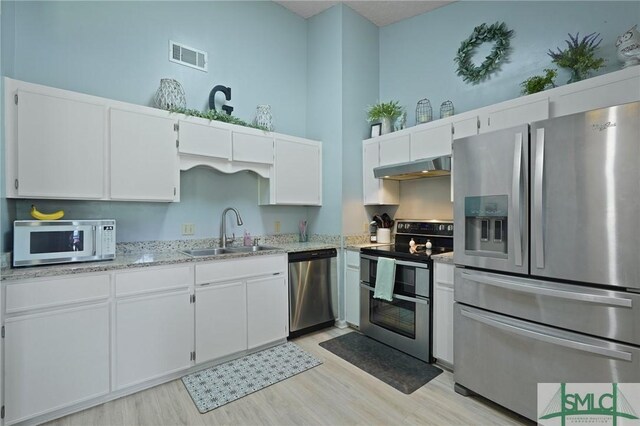 121 Pelican Ln, Richmond Hill, GA 31324 - kitchen with visible vents, appliances with stainless steel finishes, a sink, under cabinet range hood, and light wood-style flooring