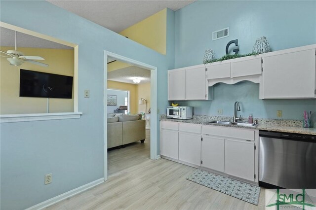 121 Pelican Ln, Richmond Hill, GA 31324 - kitchen with stainless steel dishwasher, a sink, light wood finished floors, and white microwave