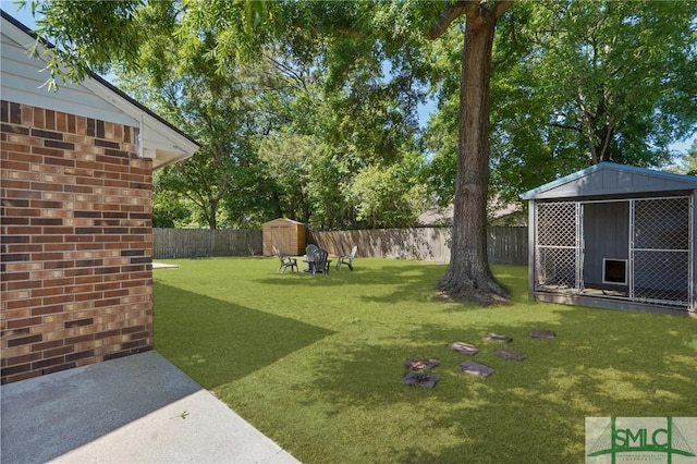 121 Pelican Ln, Richmond Hill, GA 31324 - view of yard with an outdoor structure, a fenced backyard, and a storage unit