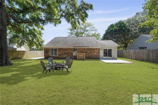 121 Pelican Ln, Richmond Hill, GA 31324 - rear view of property featuring brick siding, a fenced backyard, a patio area, and a yard