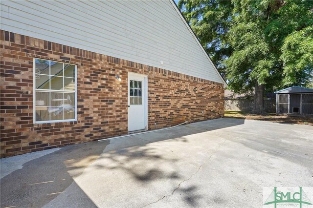 121 Pelican Ln, Richmond Hill, GA 31324 - exterior space featuring fence, a patio, and brick siding