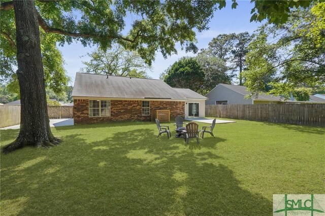 121 Pelican Ln, Richmond Hill, GA 31324 - back of house featuring a lawn and a fenced backyard