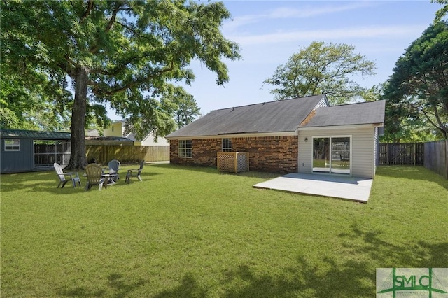 121 Pelican Ln, Richmond Hill, GA 31324 - rear view of house featuring a fenced backyard, a patio, and a lawn