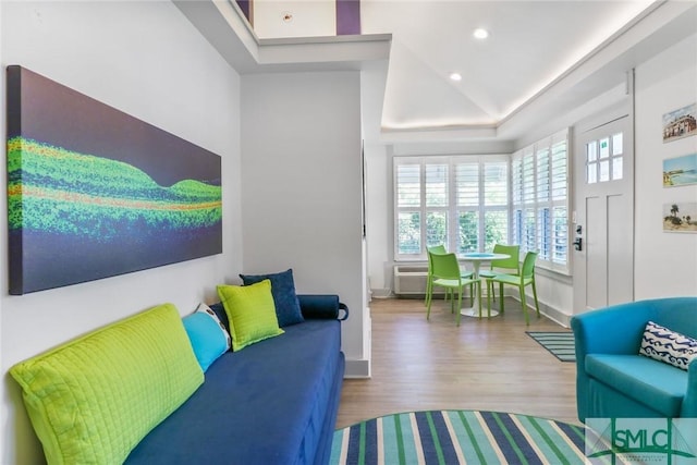 living area featuring recessed lighting, baseboards, wood finished floors, and a tray ceiling