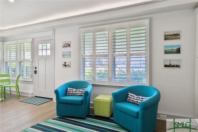 sitting room featuring baseboards, a wealth of natural light, and wood finished floors