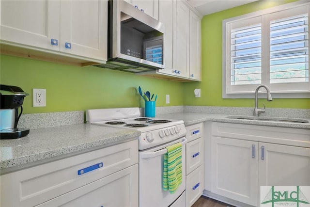 kitchen featuring white cabinets, white range with electric stovetop, light stone counters, a sink, and stainless steel microwave