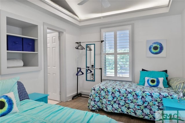 bedroom with ceiling fan, wood finished floors, and lofted ceiling