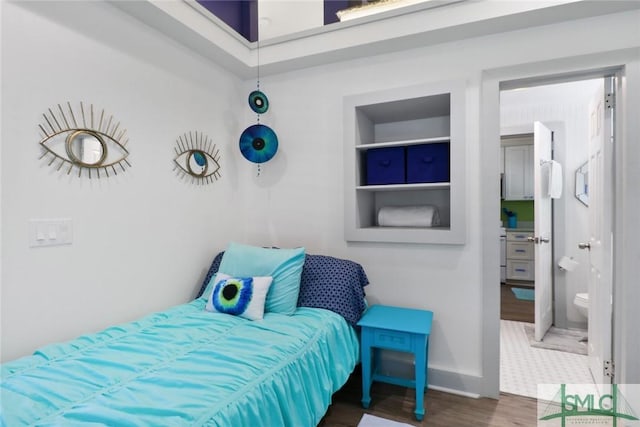 bedroom with baseboards and wood finished floors