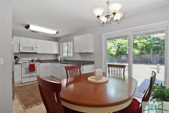 dining area with an inviting chandelier, light tile patterned floors, and visible vents