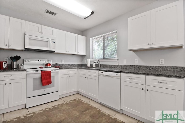kitchen featuring visible vents, a sink, light tile patterned floors, white appliances, and white cabinetry