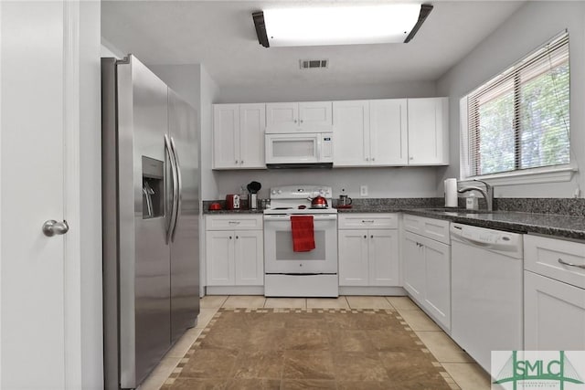 kitchen featuring visible vents, a sink, white cabinets, white appliances, and light tile patterned flooring