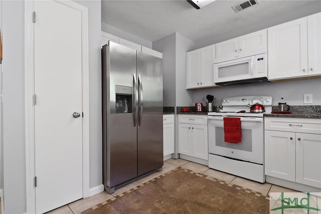 kitchen with light tile patterned floors, white cabinets, and white appliances
