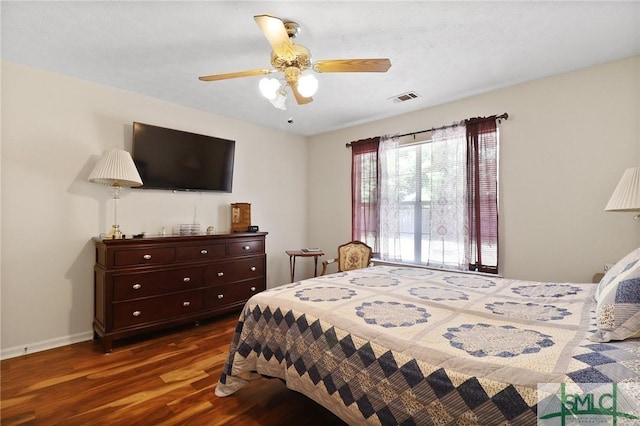 bedroom with baseboards, ceiling fan, wood finished floors, and visible vents