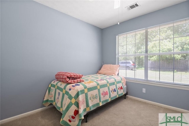 carpeted bedroom with a ceiling fan, baseboards, and visible vents