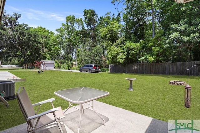exterior space featuring a yard, fence, a patio area, and an outdoor fire pit