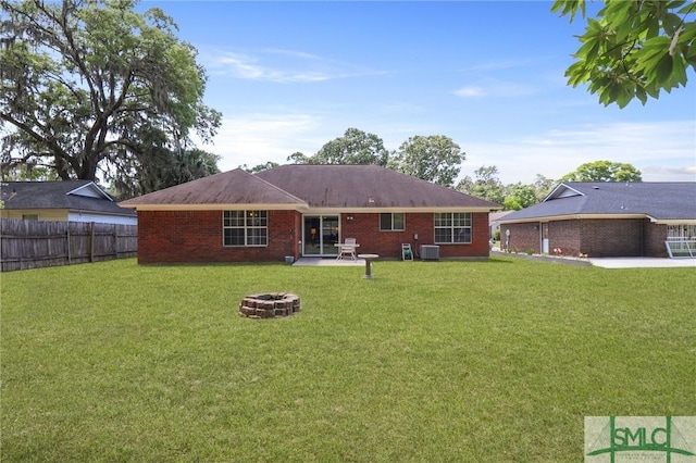 back of house with a lawn, a patio area, central AC, fence, and a fire pit