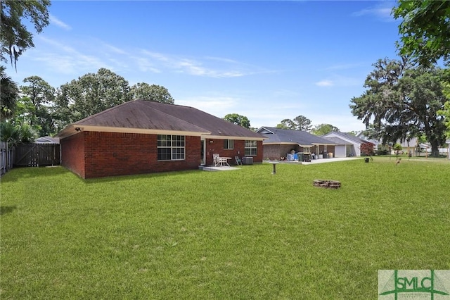 rear view of property featuring fence, a patio, and a yard