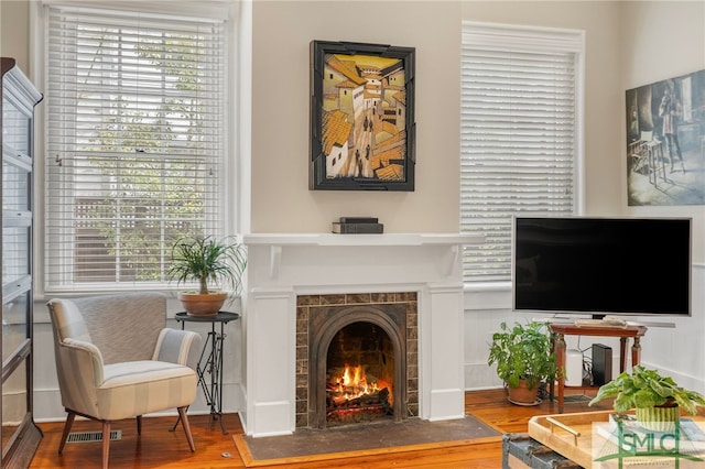 living area with wood finished floors and a tile fireplace