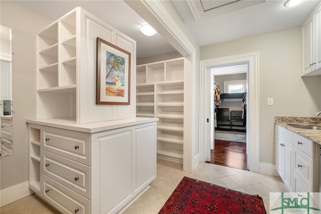 interior space featuring a sink, baseboards, and light tile patterned flooring