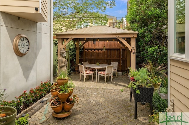 view of patio featuring a gazebo, fence, and outdoor dining area