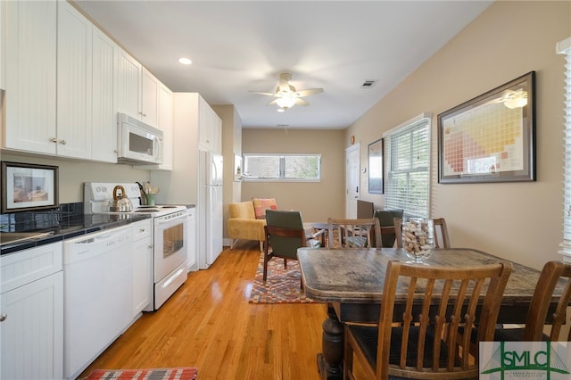 kitchen with white cabinets, light wood finished floors, white appliances, tile countertops, and visible vents