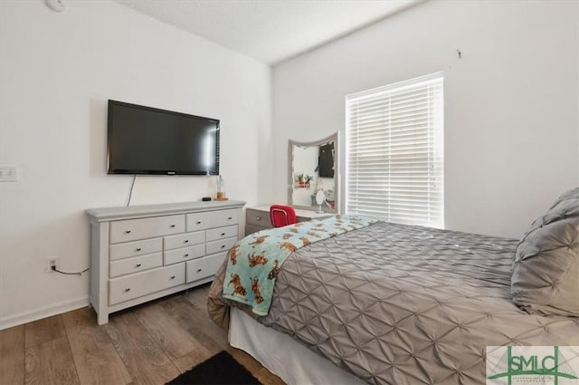 bedroom featuring baseboards and wood finished floors