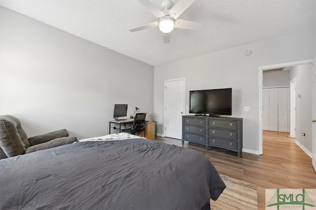 bedroom featuring a textured ceiling, baseboards, a ceiling fan, and wood finished floors