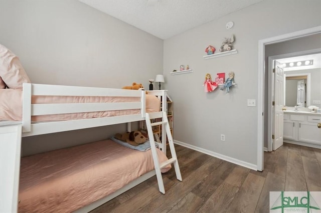bedroom with baseboards, a sink, and dark wood finished floors