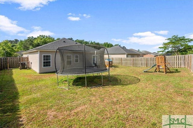 view of yard featuring a playground, central AC, a fenced backyard, and a trampoline