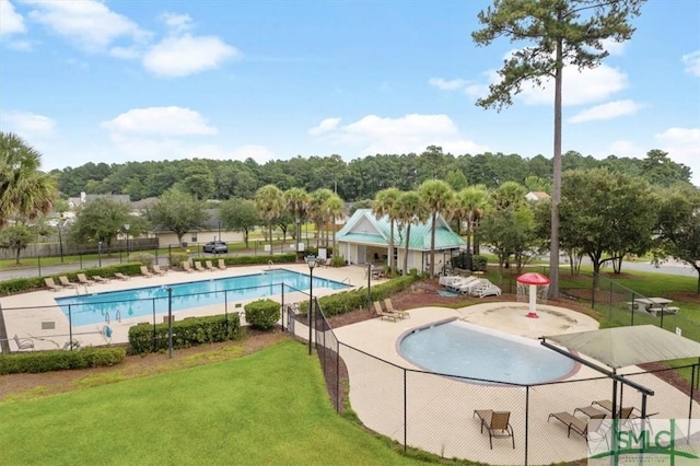 community pool featuring a lawn and fence