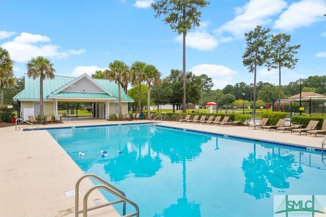 community pool featuring fence and a patio area