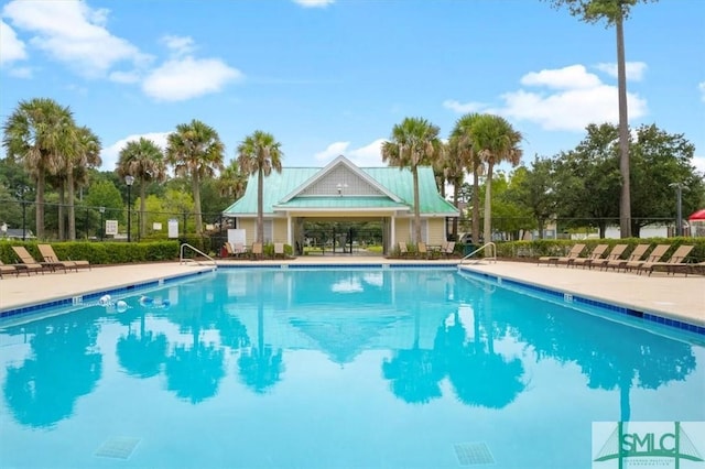 pool with a patio and fence