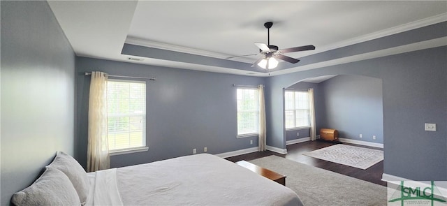 14 Canterbury Rd NE, Ludowici, GA 31316 - bedroom with arched walkways, ornamental molding, baseboards, a tray ceiling, and dark wood-style floors