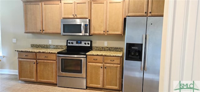 14 Canterbury Rd NE, Ludowici, GA 31316 - kitchen featuring baseboards, light stone countertops, stainless steel appliances, and light tile patterned flooring