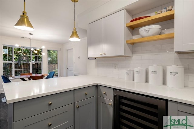 kitchen with beverage cooler, open shelves, gray cabinetry, and a peninsula