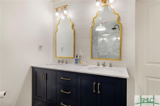 bathroom with double vanity, walk in shower, and a sink