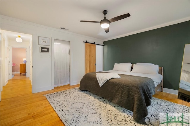 bedroom featuring baseboards, visible vents, and light wood-style flooring
