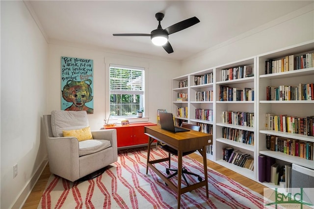 home office with crown molding, baseboards, a ceiling fan, and wood finished floors