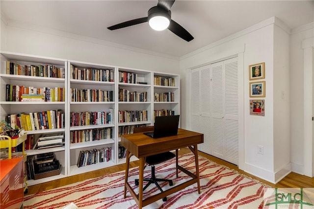 home office featuring crown molding, ceiling fan, and wood finished floors