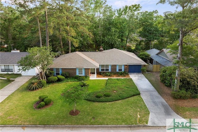 single story home with fence, an attached garage, driveway, and a front yard