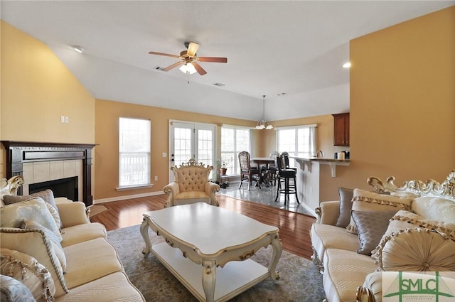 living room with a ceiling fan, baseboards, lofted ceiling, and a fireplace