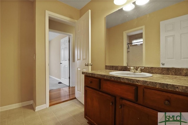 bathroom with vanity, baseboards, and tile patterned flooring