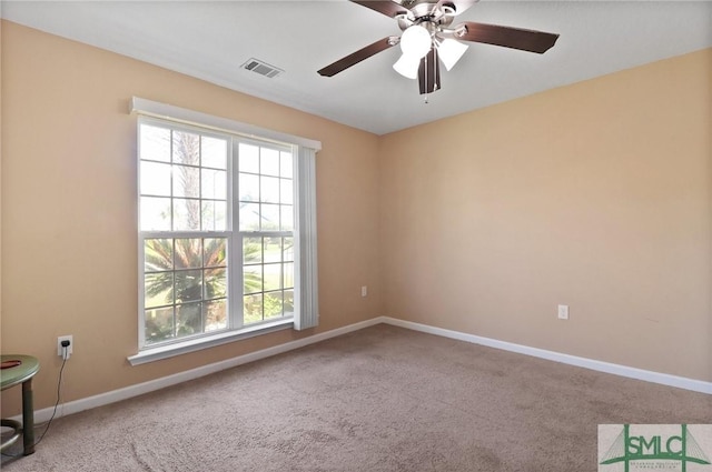 carpeted empty room featuring ceiling fan, visible vents, plenty of natural light, and baseboards