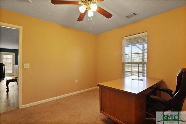 office with light colored carpet, a ceiling fan, visible vents, and baseboards
