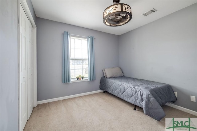 carpeted bedroom featuring baseboards, visible vents, and a closet