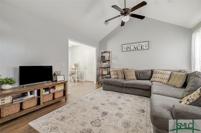 living room with ceiling fan, wood finished floors, and lofted ceiling