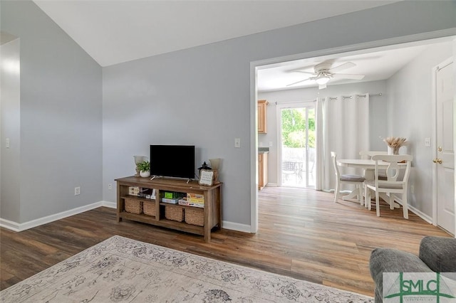 living area featuring a ceiling fan, baseboards, and wood finished floors