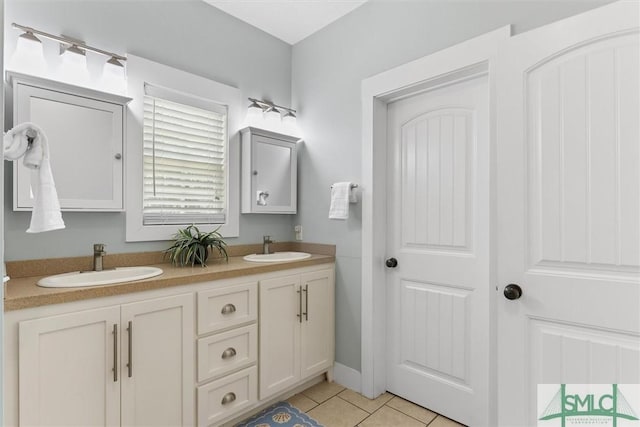 bathroom with double vanity, tile patterned floors, and a sink